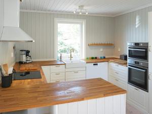eine Küche mit weißen Schränken und einer Holzarbeitsplatte in der Unterkunft 4 star holiday home in STRÖMSTAD-By Traum in Strömstad