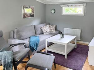 een woonkamer met een bank en een tafel bij Holiday home KARLSHAMN III in Karlshamn