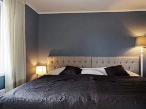 a bedroom with a large bed with a blue wall at Holiday home Grebbestad XII in Grebbestad
