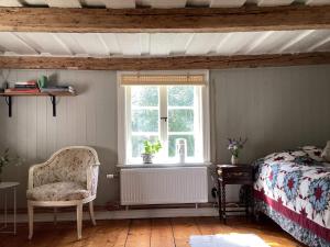 um quarto com uma cama, uma cadeira e uma janela em Holiday home Uppsala em Uppsala