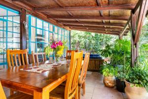 a wooden table and chairs on a patio with plants at Tafat's Haven Lodge in Nurit