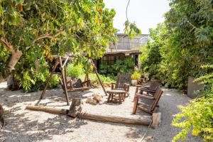 a group of chairs and a swing in a yard at Tafat's Haven Lodge in Nurit