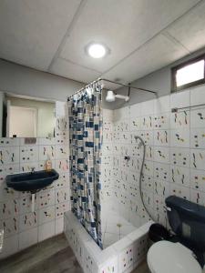 a bathroom with a sink and a toilet and a shower at Hermosa suite acogedora, Las Garzas in Guayaquil