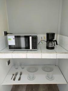a microwave sitting on top of a kitchen counter at Hermosa suite acogedora, Las Garzas in Guayaquil