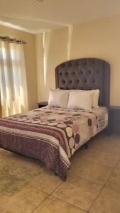 1 dormitorio con 1 cama grande y cabecero grande en Casa en condominio en Quetzaltenango