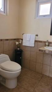 uma casa de banho com WC, lavatório e toalhas em Casa en condominio em Quetzaltenango