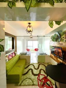 a living room with a green couch and a table at Stunning Taal View Staycation in Tagaytay in Tagaytay