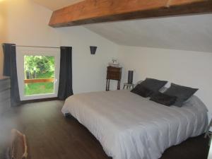 1 dormitorio con cama blanca y ventana en Les Cimes, en Saint-Pierre-de-Rivière