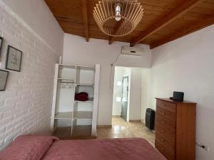 - une chambre avec un lit et un plafond en bois dans l'établissement Cómodo dúplex en Pasaje Tucumán, à Alta Gracia