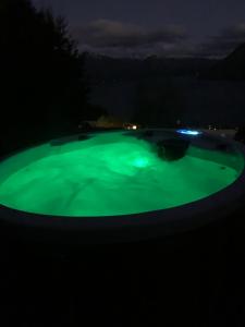 einen Pool mit grünem Wasser in der Nacht in der Unterkunft Rivendell, Luxury Cliff Top Home, Queenstown - Spa & Sauna in Queenstown