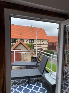 a balcony with a chair and a view of a building at Monteurswohnung am Ederseeradweg mit 2 Schlafzimmern, Terrasse, Parkplatz - Wohnung 1 in Waldeck