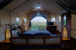 1 dormitorio con 1 cama y ventana grande en Arkamaya Kusuma Resort en Yogyakarta