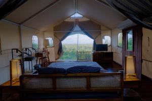 una camera da letto con un letto con una grande finestra di Arkamaya Kusuma Resort a Yogyakarta