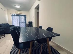 a black table with chairs in a living room at JR GUESTHOUSE in Ampang