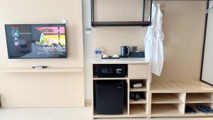 a kitchen with a microwave and a tv in a room at The Aurora Home near International Airport in Miếu Ông