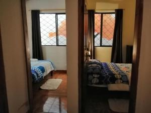 - une chambre avec 2 lits et 2 fenêtres dans l'établissement Home Capybara Stay, à Mindo