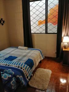 een slaapkamer met een bed en een glas-in-loodraam bij Home Capybara Stay in Mindo