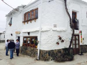 a group of people standing outside of a white building at L'atelier B&B in Mecina Fondales