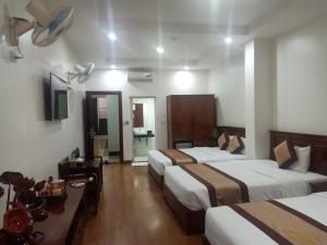 een hotelkamer met 2 bedden en een televisie bij Khách Sạn Sông Hiến in Cao Bằng
