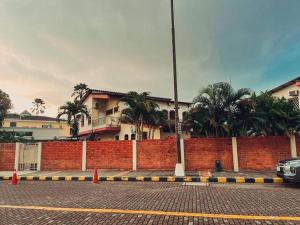 een gebouw met palmbomen en een stenen muur bij Hermosa suite acogedora y hermosa, Las Garzas 2 in Guayaquil