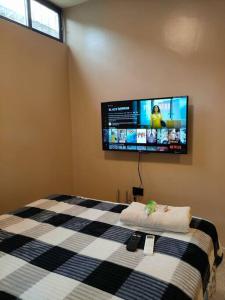 een slaapkamer met een bed en een tv aan de muur bij Hermosa suite acogedora y hermosa, Las Garzas 2 in Guayaquil