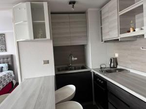 a small kitchen with white cabinets and a sink at Bideluxe Apart Hotel in Los Ángeles