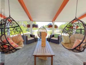 a porch with two hanging chairs and a table at Tide Pool Cabin, a Soquinomere Private Hotel on the Dunes, Downtown Ocean Shores in Ocean Shores