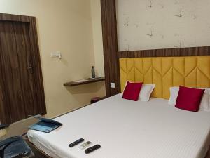 1 dormitorio con 1 cama con ordenador portátil en The A Cube Inn, en Bokāro