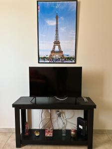 a table with a tv and a picture of the eiffel tower at Departamento Centrico in Villa María +7 photos