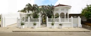 a white fence in front of a house with potted plants at Casa Hotel Terraza del Cabrero in Cartagena de Indias