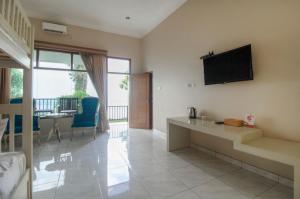 un salon avec une télévision à écran plat au mur dans l'établissement kahai beach hotel, à Waimuli