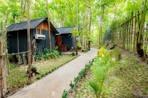 una casa en un bosque con un camino de tierra en Arkamaya Kusuma Resort en Yogyakarta