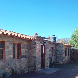 an old stone building with a red door at Hostal Samary Wasi in Estancia Chaunaca