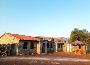 een oud stenen huis aan de kant van een weg bij Hostal Samary Wasi in Estancia Chaunaca