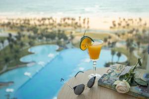 uma bebida sentada numa mesa ao lado de uma piscina em Kim Hana Cam Ranh em Cam Ranh