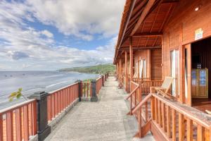 a building with a balcony looking out at the ocean at Manta Cottage Seaview Plus in Nusa Penida