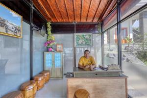 a man sitting at a counter in a restaurant at Manta Cottage Seaview Plus in Nusa Penida