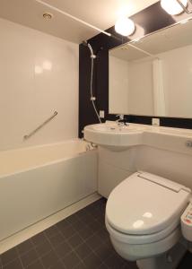 een badkamer met een toilet, een wastafel en een bad bij Hotel Sunroute Fukuchiyama in Fukuchiyama