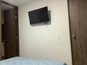 a bedroom with a flat screen tv on the wall at Cómoda habitación con baño privado in Sabaneta