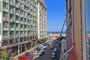 a view of a city street with parked cars at Studio com vista lateral para o mar em Copacabana in Rio de Janeiro