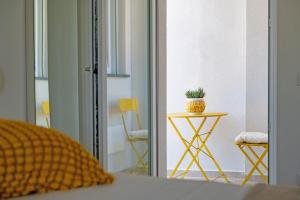 un dormitorio con una mesa con una planta en CALLIA ROOMS PROCIDA, en Procida