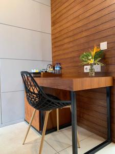 un bureau en bois avec une chaise et un vase de fleurs dans l'établissement Bale Solah Lombok Holiday Resort, à Senggigi