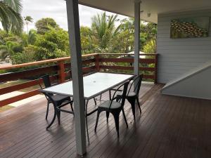 una mesa y sillas en un porche con terraza en Endeavour Reach, en Cooktown