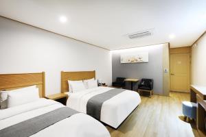 a hotel room with two beds and a desk at Paju Golden Hill in Paju