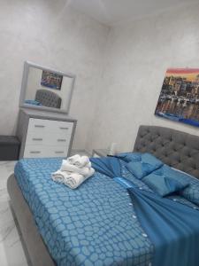 - une chambre avec un lit bleu et des serviettes dans l'établissement Casa Vacanza da Nunzio, à Torre Annunziata