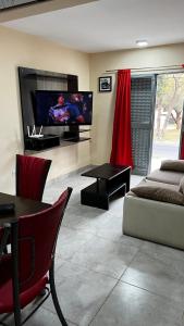 ein Wohnzimmer mit einem Flachbild-TV und einem Sofa in der Unterkunft Las Rejas Departamento in San Fernando del Valle de Catamarca