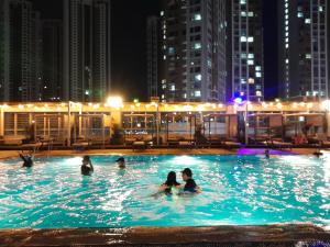 a group of people in a swimming pool at night at Songdo Halla Westernpark Hotel in Incheon