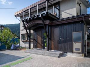 a house with a balcony on the side of it at Oguma House in Nozawa Onsen