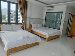 a bedroom with two beds and a large window at HOTEL VTV DỐC LẾT in Ninh Hòa