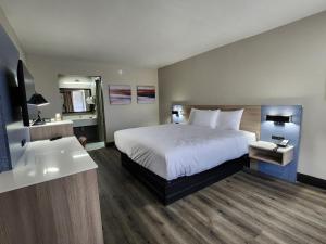 a hotel room with a bed and a sink at Smart Stay Lafayette in Lafayette